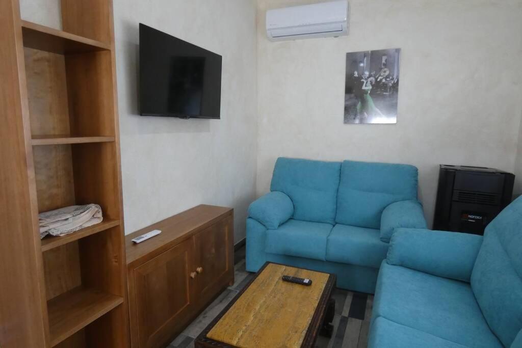 a living room with a blue couch and a tv at CASA RURAL LA BLANQUITA in Bullas