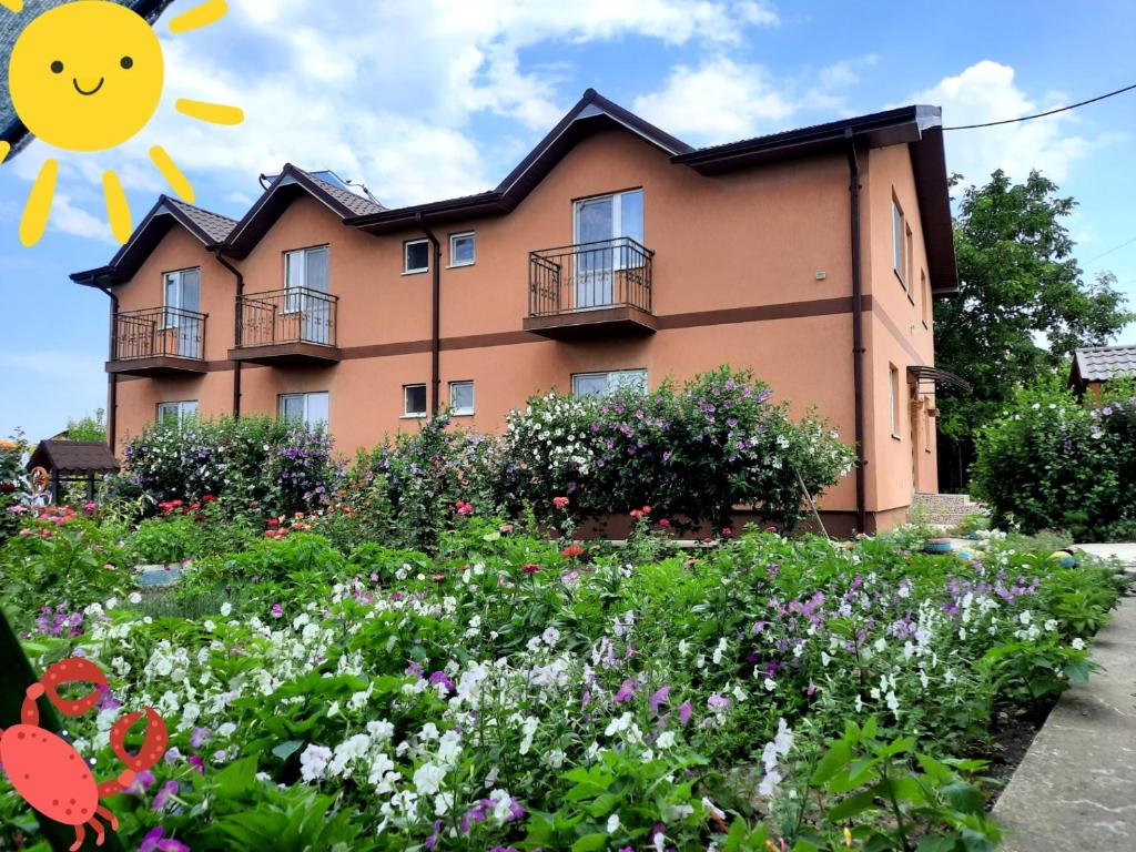 a house with a flower garden in front of it at Casa cu flori in Tuzla