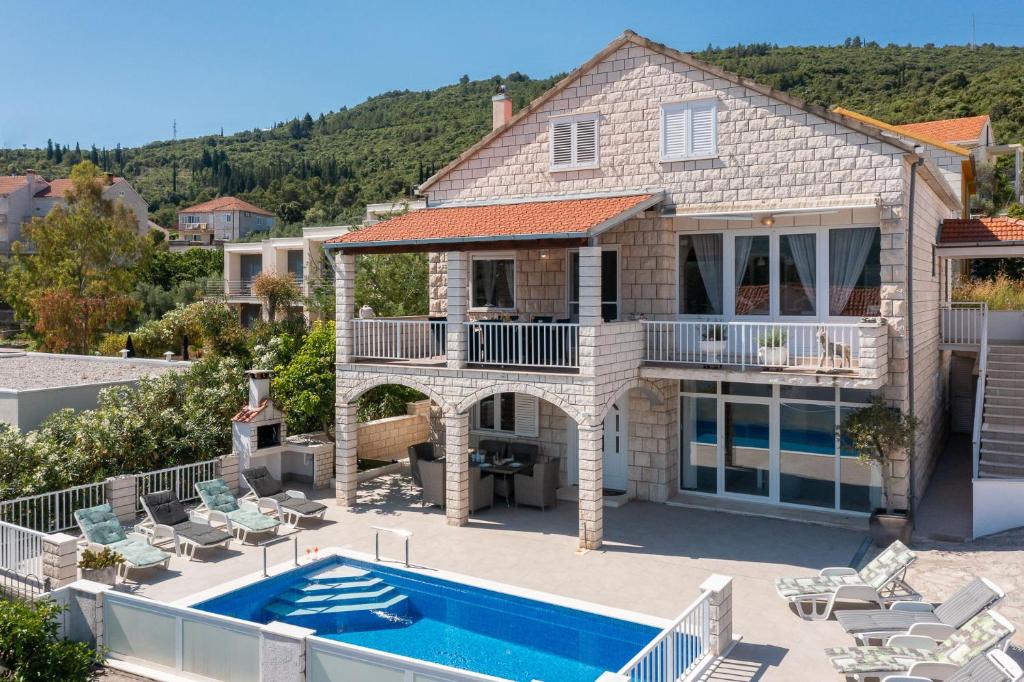 a villa with a swimming pool and a house at Appartements Banya in Korčula