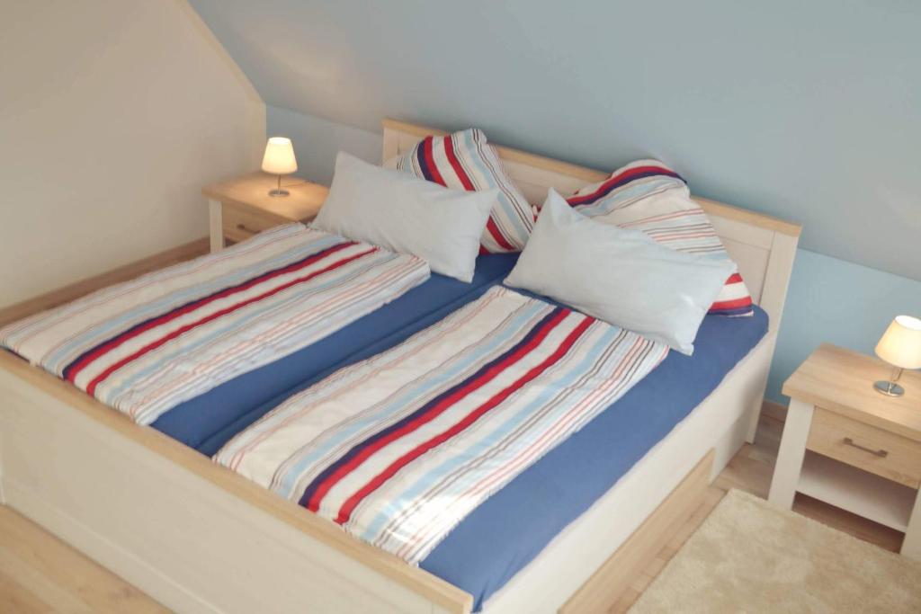 Una cama con sábanas y almohadas de rayas coloridas. en Ferienwohnung Prange Cuxhaven, en Cuxhaven