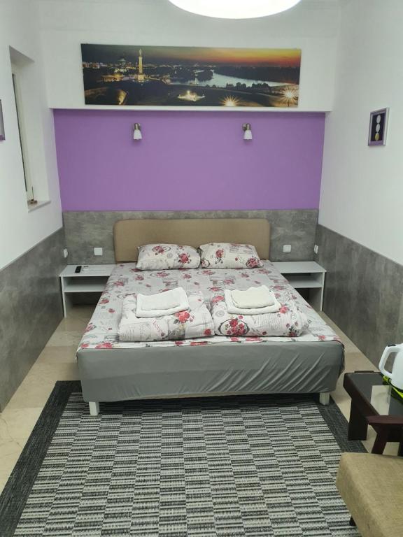 a bedroom with a bed with a purple wall at Apartment Jelić in Belgrade