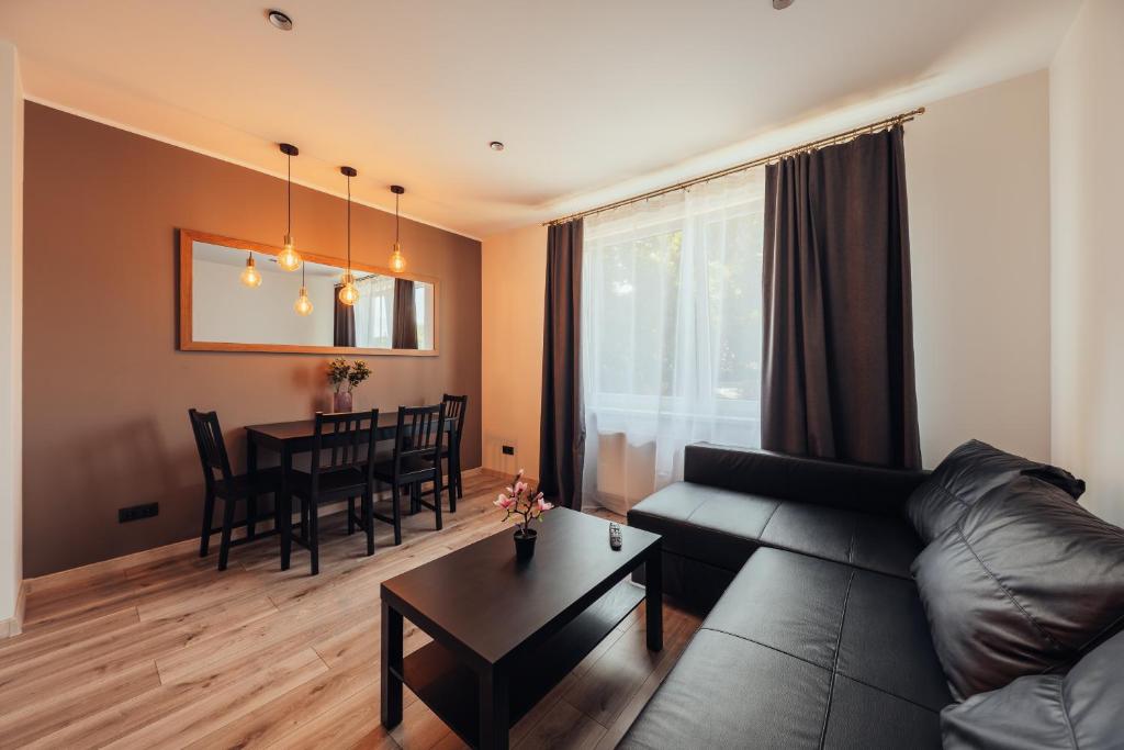 - un salon avec un canapé et une table dans l'établissement Poorbaltics Apartments, à Liepāja
