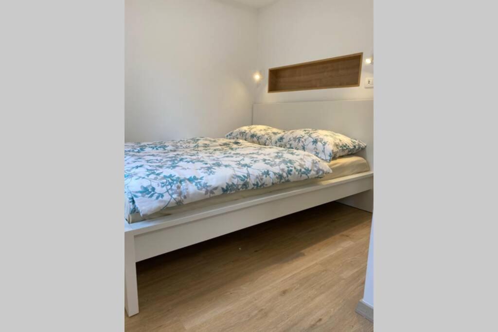 a bedroom with a white bed with blue sheets at STUDIO BELA in Radovljica