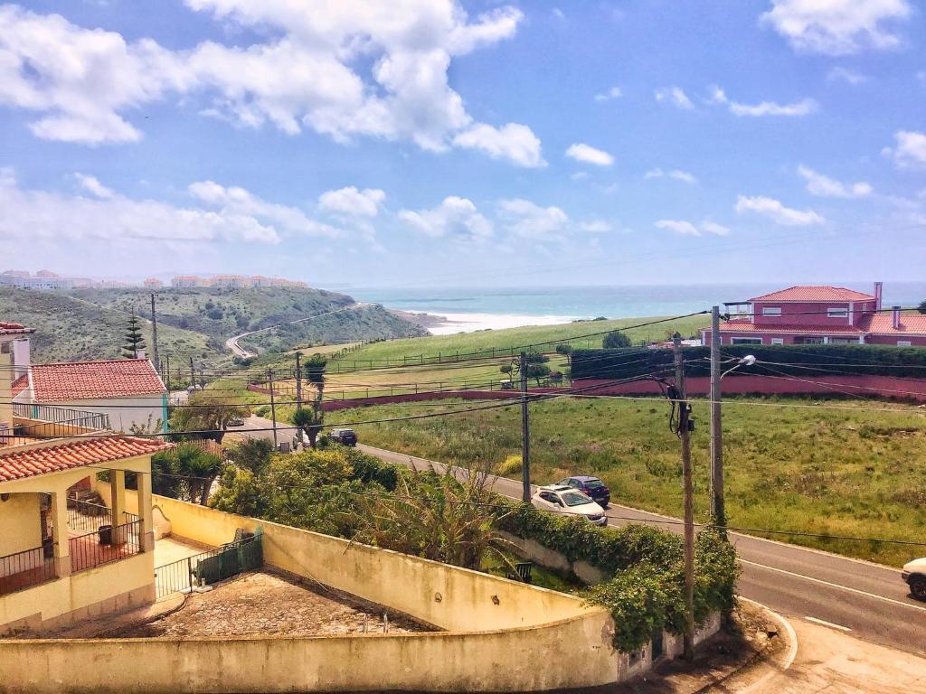 una vista di una strada con una casa e l'oceano di Villa Peponi a Ericeira