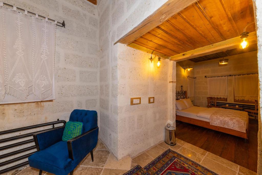 een slaapkamer met een bed en een blauwe stoel in een kamer bij terracota hotel in Nevsehir