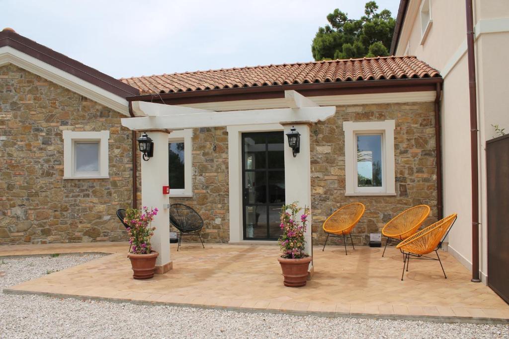 een patio met stoelen en bloemen voor een huis bij Tenuta Bellelli in Castellabate