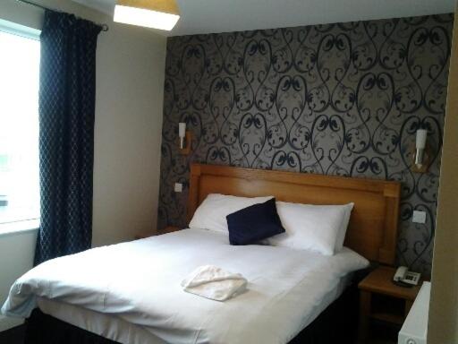 Un pat sau paturi într-o cameră la Creighton Hotel