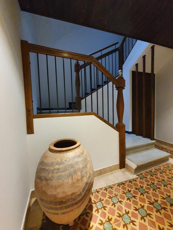 a vase sitting on a floor next to a staircase at Casa Rural Hospitalero 