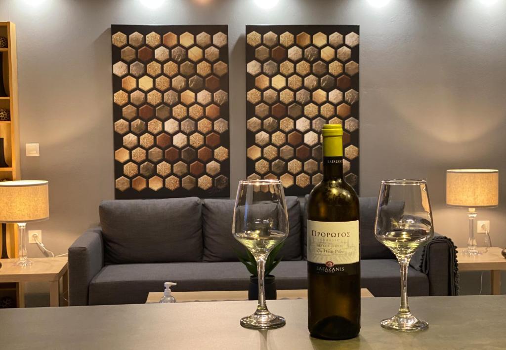 uma garrafa de vinho e dois copos numa mesa em Ninemia luxury apartments em Xylokastron