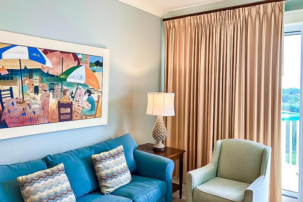 a living room with a blue couch and a chair at The Grand #2703 in Destin