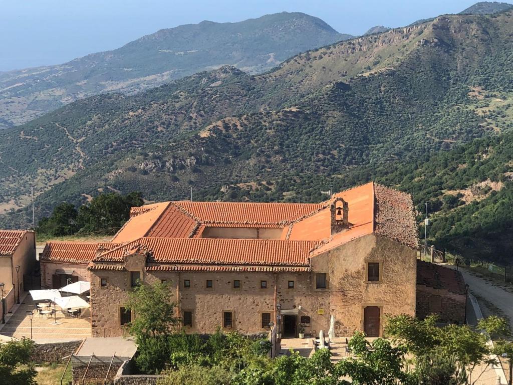 a large stone building with mountains in the background at Al Convento in San Mauro Castelverde