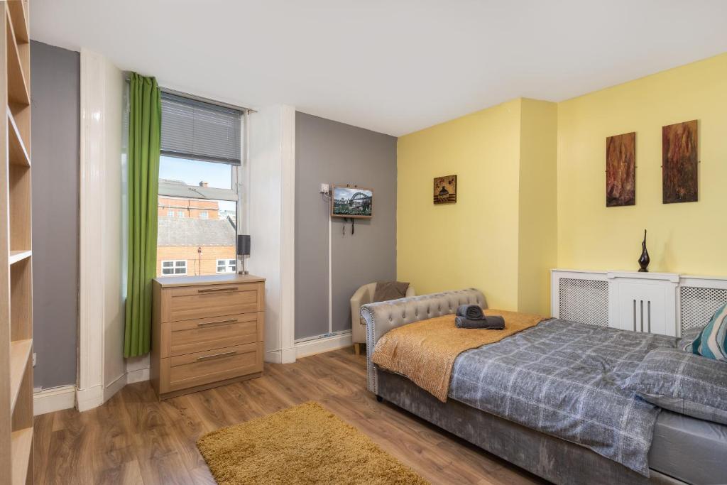 a bedroom with a bed and a dresser and a television at CITY CENTRE en-suite rooms in Sunderland