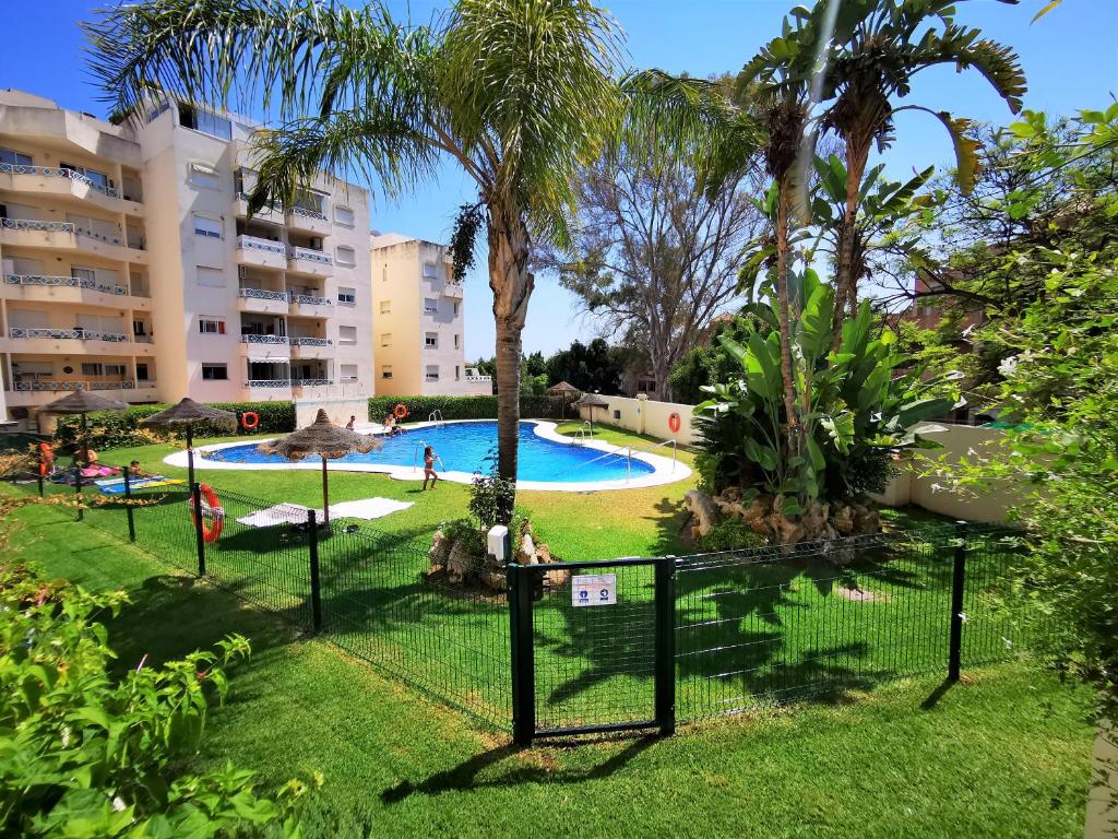 - une vue sur la piscine d'un complexe avec des palmiers dans l'établissement Arena CARPE DIEM MARBELLA, à Marbella