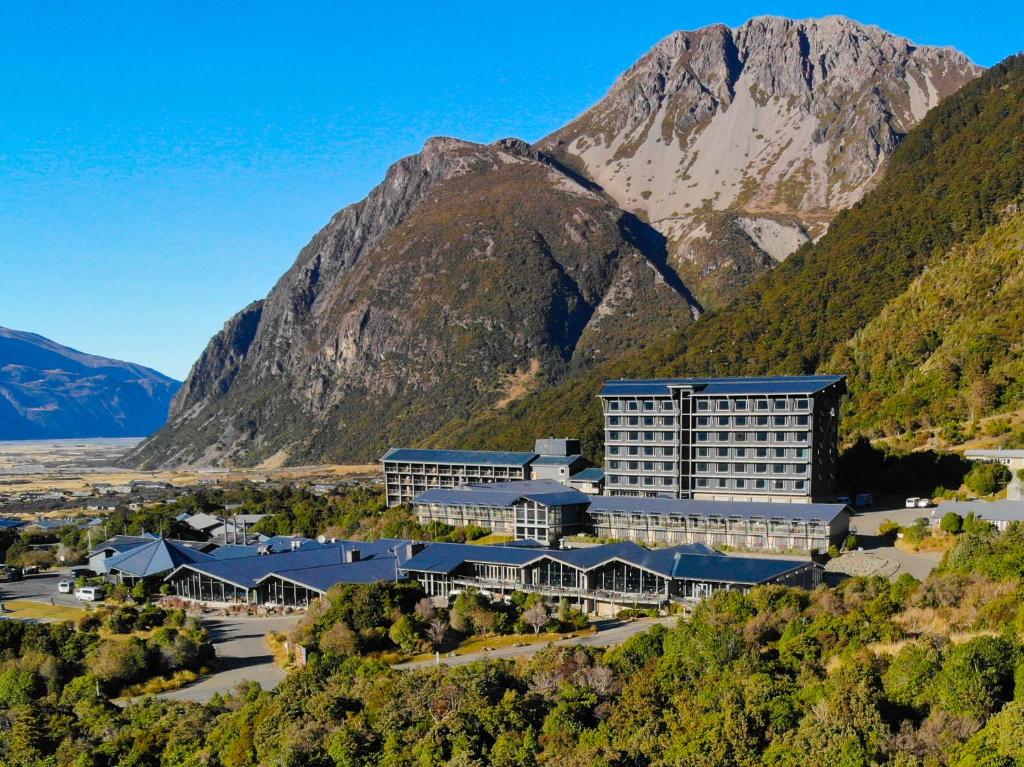 una vista aérea del impresionante hotel con montañas en el fondo en The Hermitage Hotel Mt Cook, en Mount Cook Village