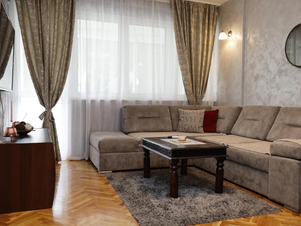 Apartment Mona في بودغوريتسا: غرفة معيشة مع أريكة وطاولة قهوة