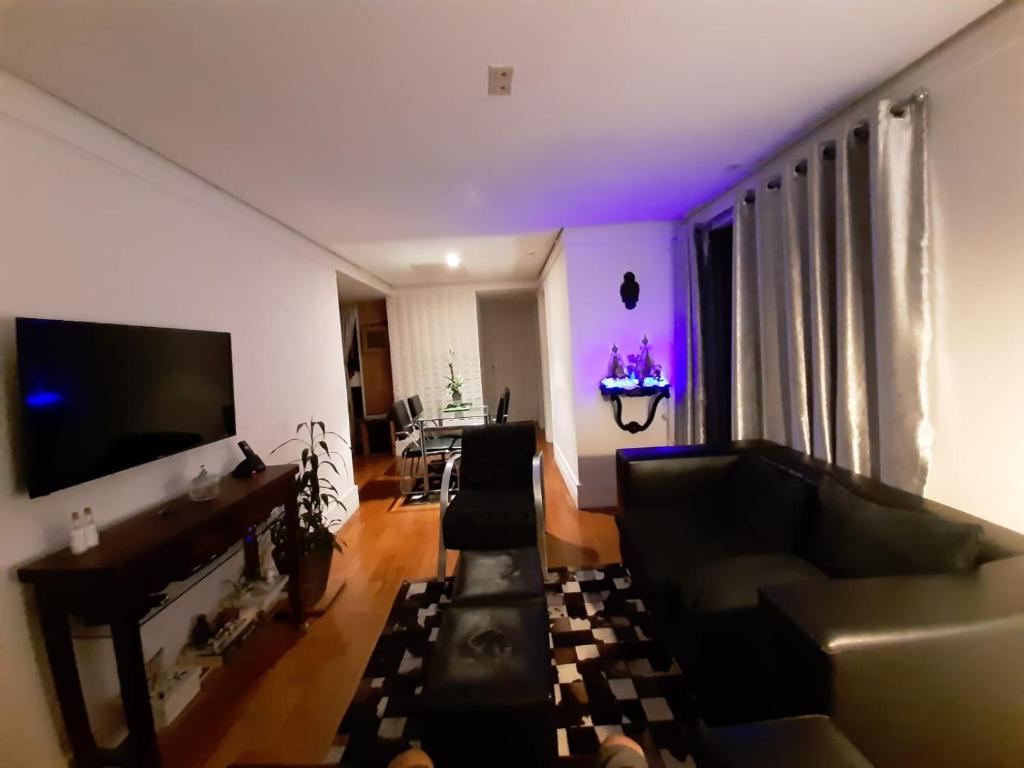 salon z kanapą i telewizorem w obiekcie Quartos Vila Augusta/Guarulhos w mieście Guarulhos