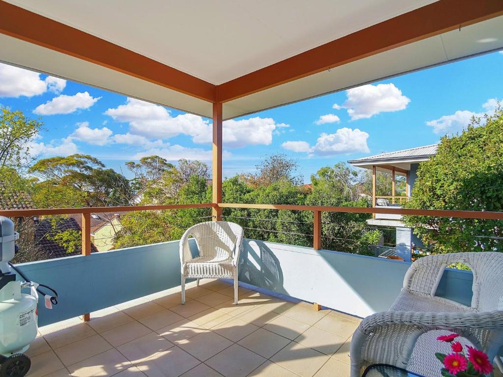a balcony with two chairs and a view of trees at Bella on Jervis by Experience by Jervis Bay in Vincentia