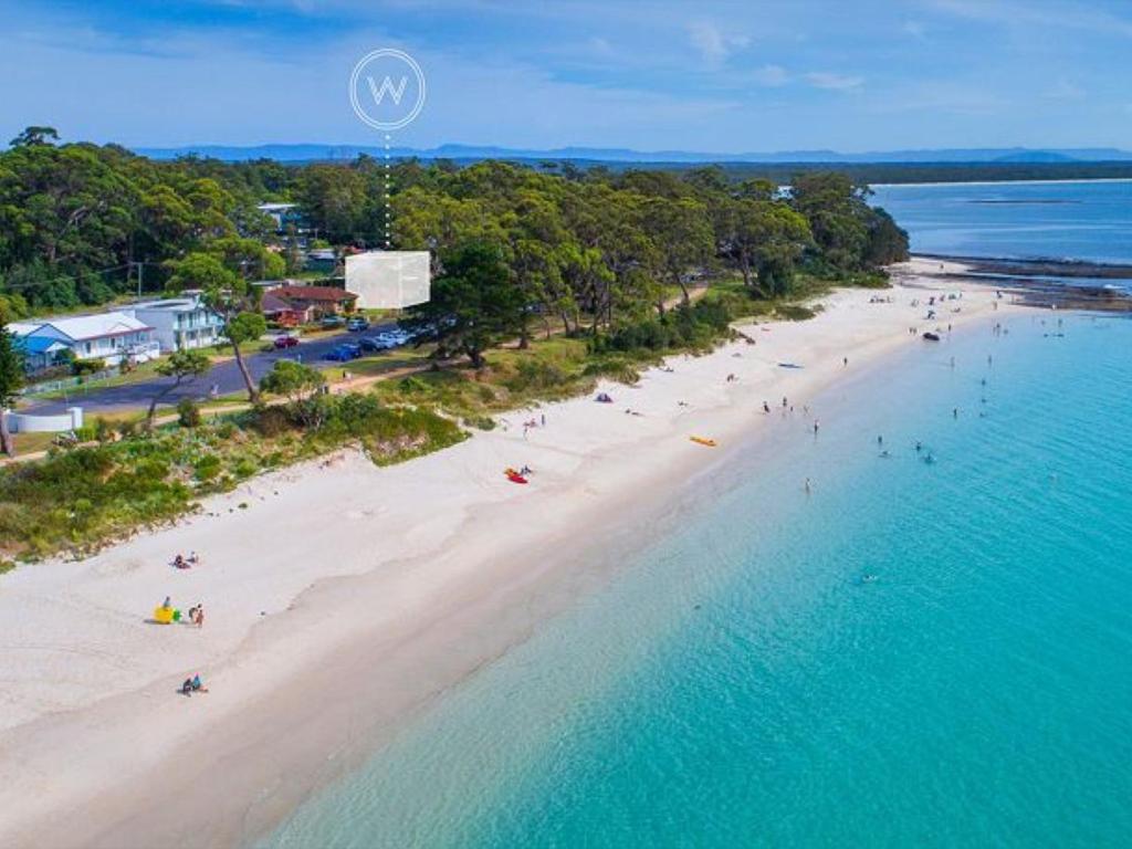 an aerial view of a beach with people in the water at Beachfront Luxury by Experience Jervis Bay in Huskisson