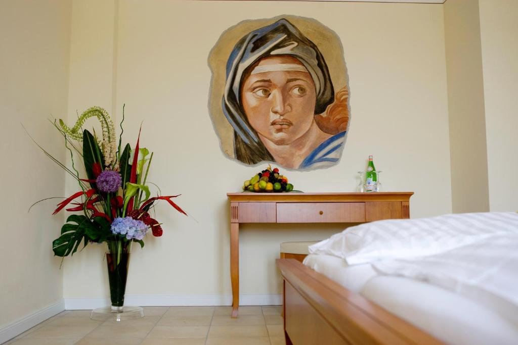a bedroom with a painting of a woman on the wall at XII Apostel Albergo in Cologne