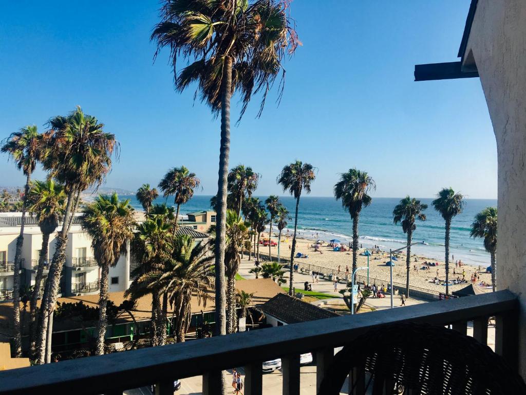 een uitzicht op een strand met palmbomen en de oceaan bij See By The Sea in San Diego