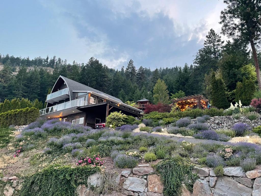 a house in the middle of a garden with flowers at Les Chambres Roses in West Kelowna