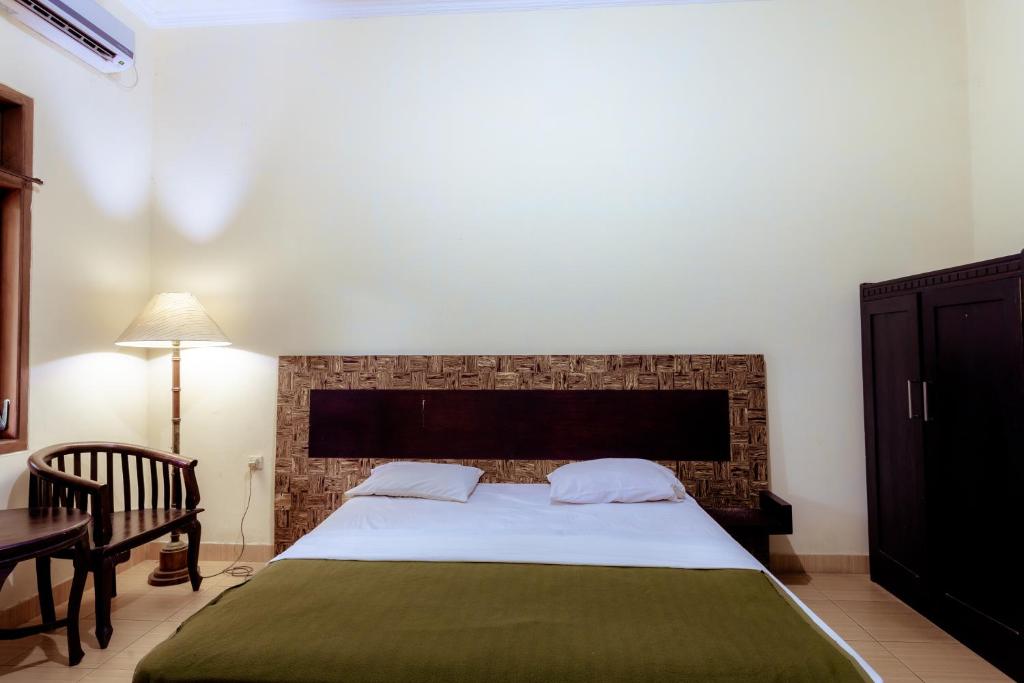 Postel nebo postele na pokoji v ubytování Hotel Mahkota Plengkung by ecommerceloka