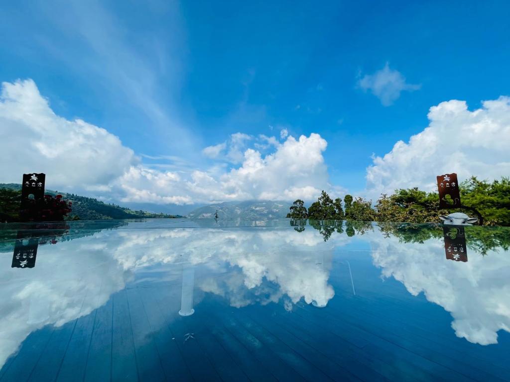 a reflection of the sky in a pool of water at Ailiga Travel Villa in Ren&#39;ai