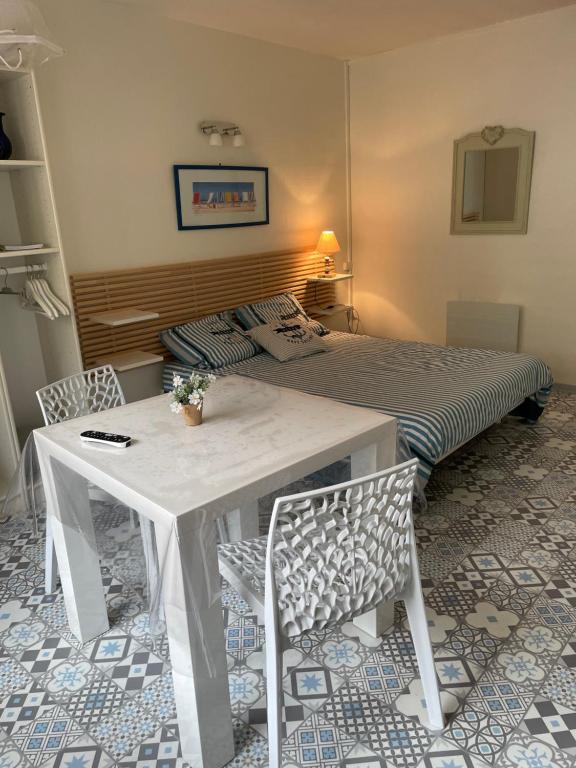 une chambre avec un lit, une table et des chaises dans l'établissement A l'Ancre Bleue, au Tréport