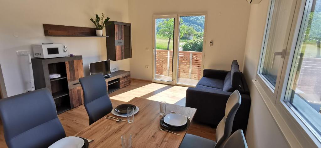 een woonkamer met een houten tafel en stoelen bij Apartmaji Tmaynka in Tolmin