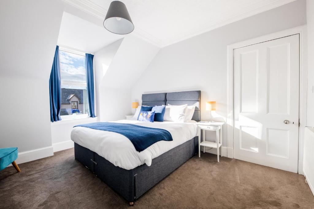 a bedroom with a large bed and a window at Dryburgh Apartments No2 in Inverness