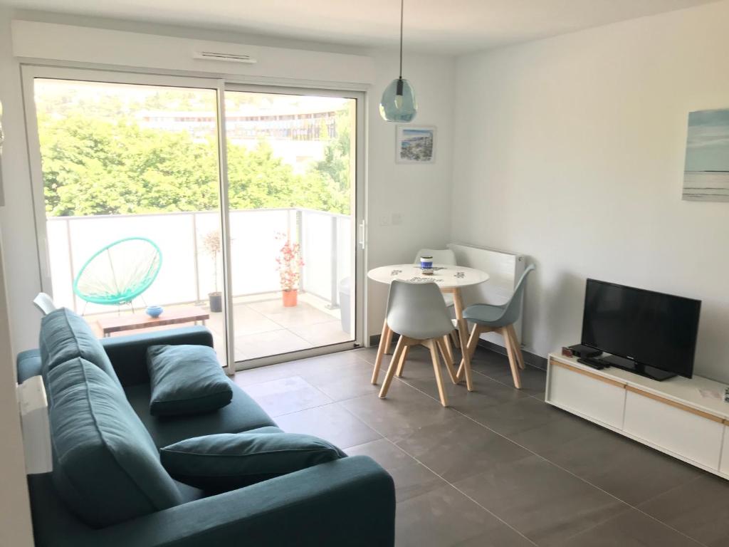 un salon avec un canapé bleu et une table dans l'établissement Appartement à Nice, à Nice