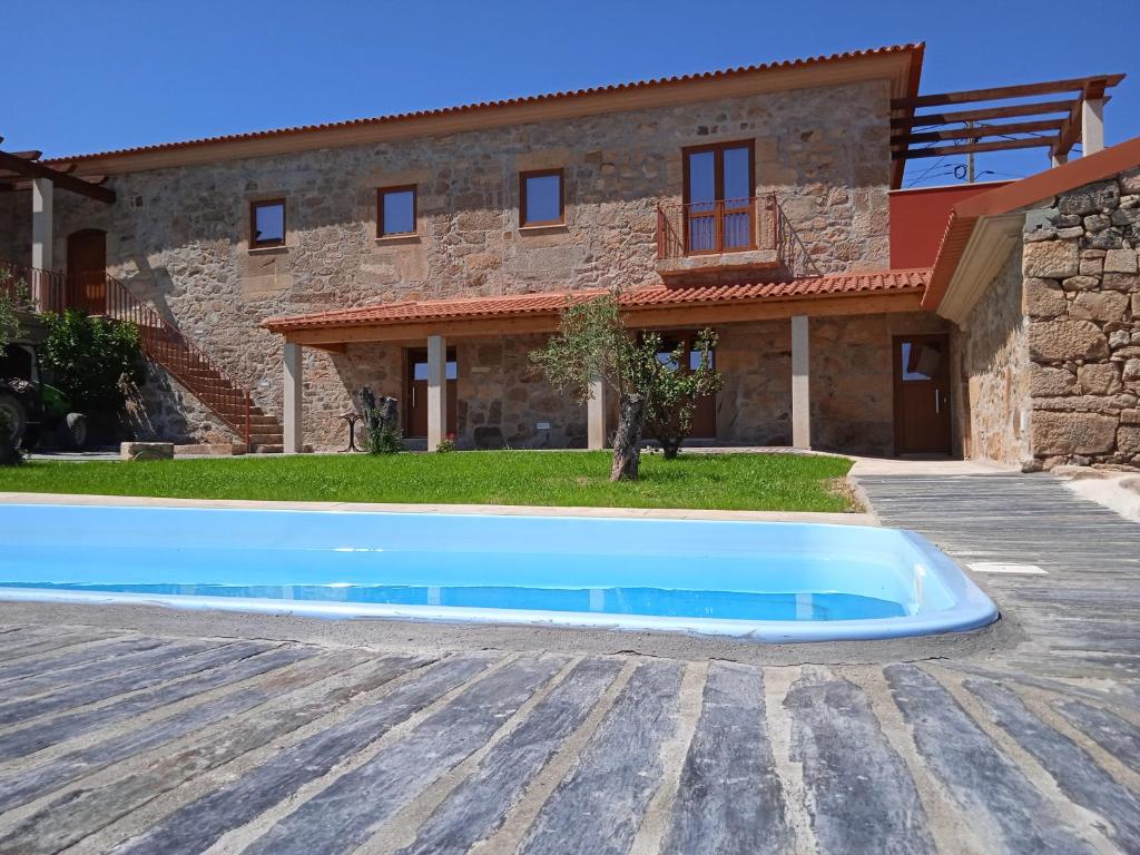 a house with a blue swimming pool in front of it at Quinta do Passadiço in Lamego