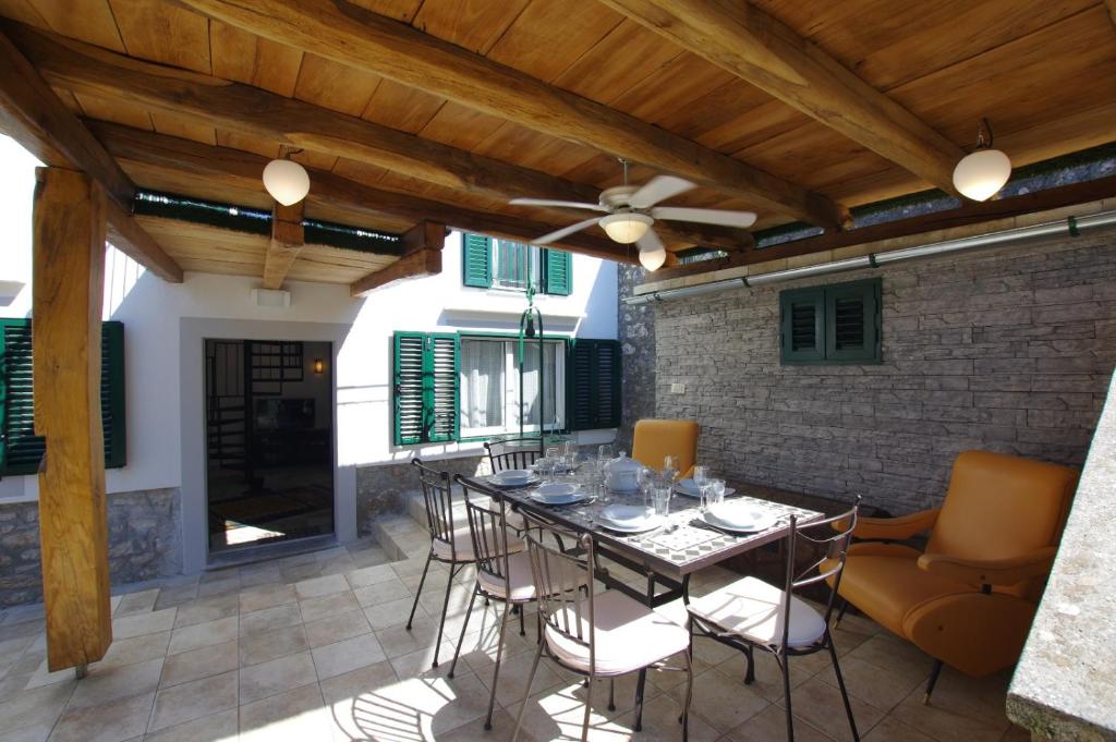 patio con tavolo, sedie e soffitto di Villa Malena a Mali Lošinj (Lussinpiccolo)