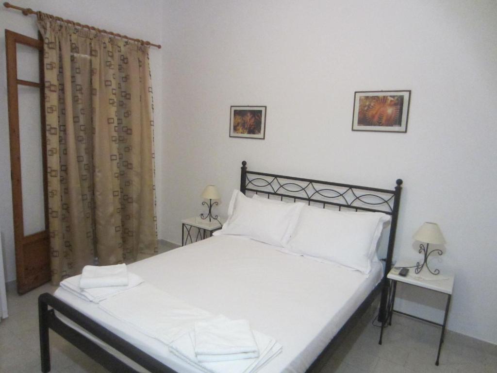 1 dormitorio con 1 cama con sábanas y almohadas blancas en Katerina Apartments, en Triovasálos