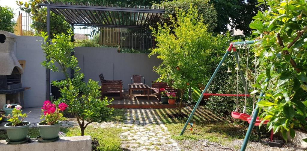 um jardim com um baloiço e algumas plantas em Apartment FINI em Tivat