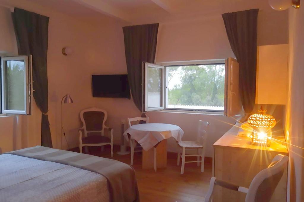 Habitación de hotel con cama, mesa y ventana en Henry Agriturismo Manfredonia, en Ippocampo