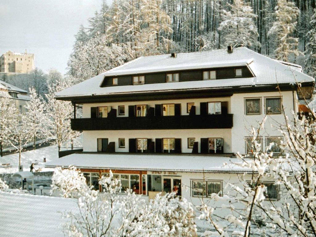 a large building covered in snow with snow covered trees at Hotel Bologna in Brunico