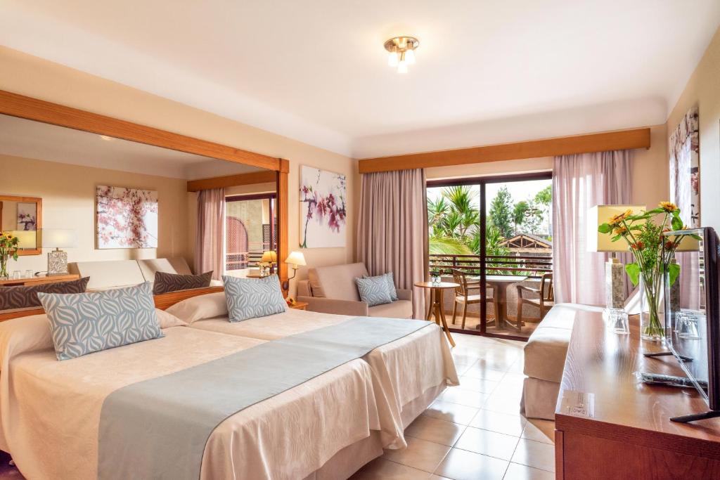 a bedroom with two beds and a living room at GF Fañabe in Adeje