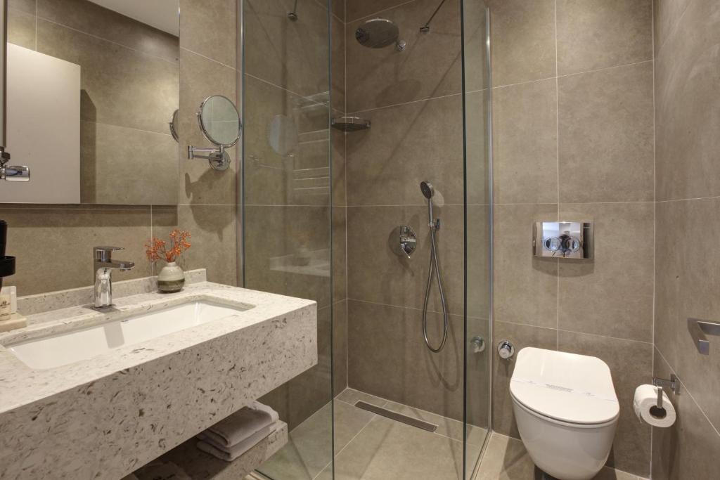 a bathroom with a shower and a toilet and a sink at The Pearl Suites in Istanbul
