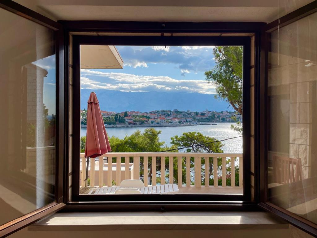 ventana con vistas a un balcón con sombrilla en Sea & Relax en Selca