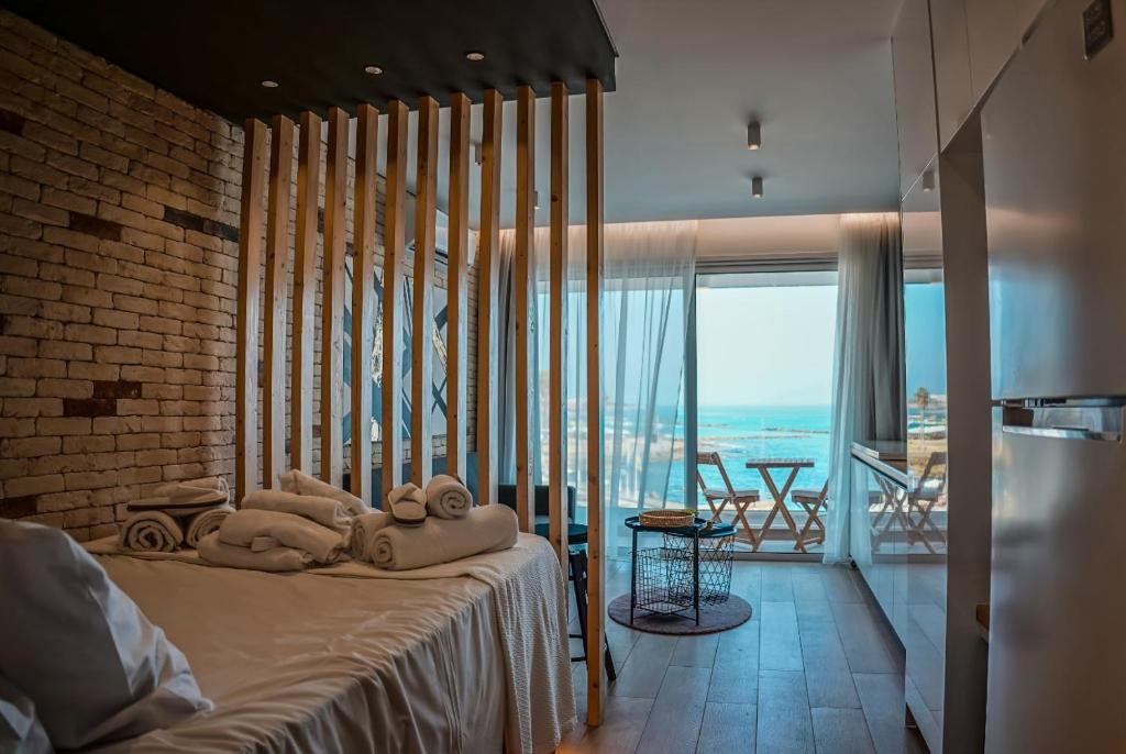a bedroom with towels on a bed with a balcony at COSea Living: SeaSide Luxury Suite in Harbour 107A in Paphos City