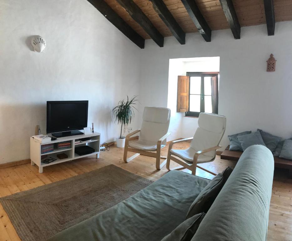 - un salon avec un canapé, des chaises et une télévision dans l'établissement Casa do Pelourinho, à Aljezur