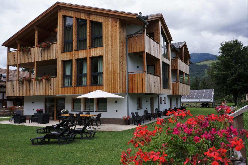 een groot gebouw met tafels, stoelen en bloemen bij Mas dei Masi in Cavalese