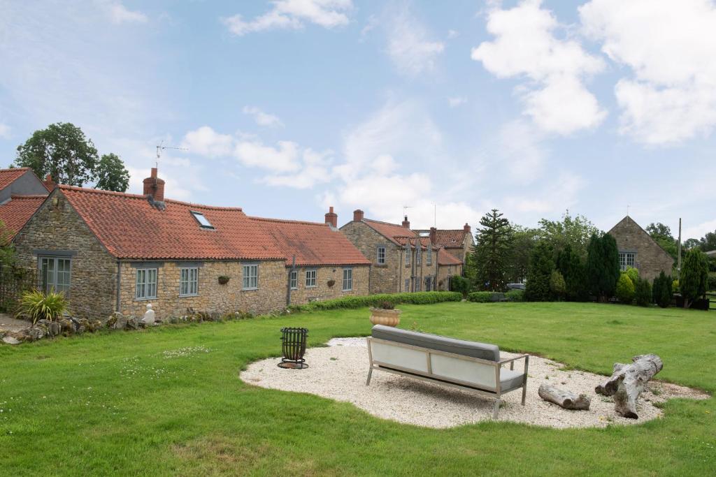 a park bench in front of a house at Sands Farm Cottages in Thornton Dale