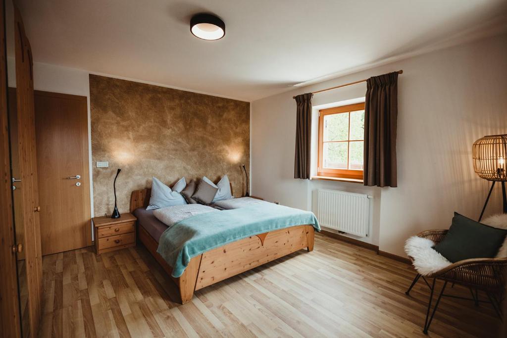 um quarto com uma cama, uma janela e uma cadeira em Apartment Andreas - Gallhof em Vollan