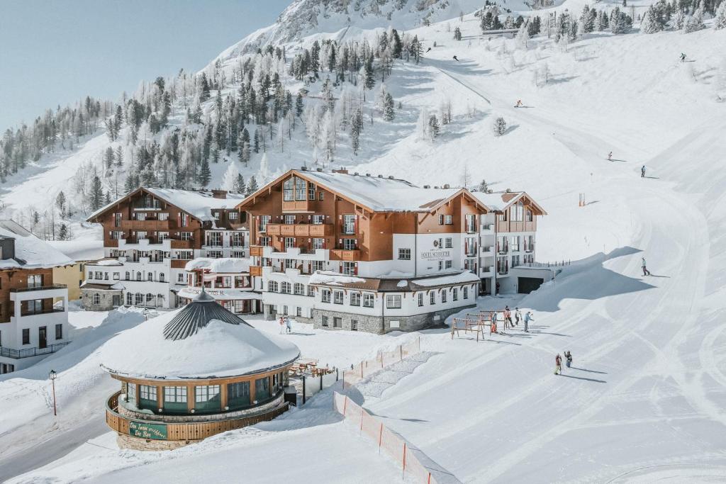 een skihut in de sneeuw met besneeuwde gebouwen bij Superior Hotel Schneider Ski-in & Ski-out in Obertauern