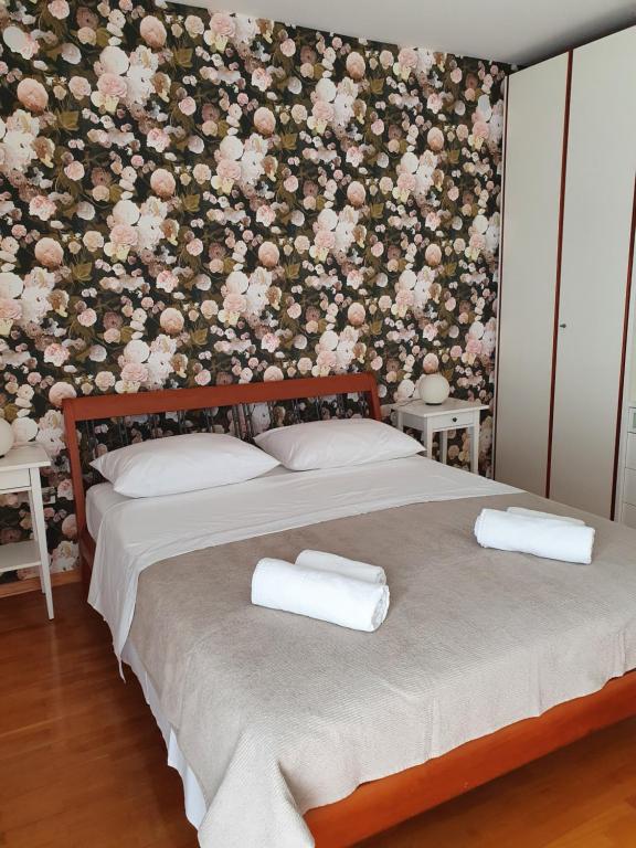a bedroom with a bed with a floral wall at Apartment Tina in Split