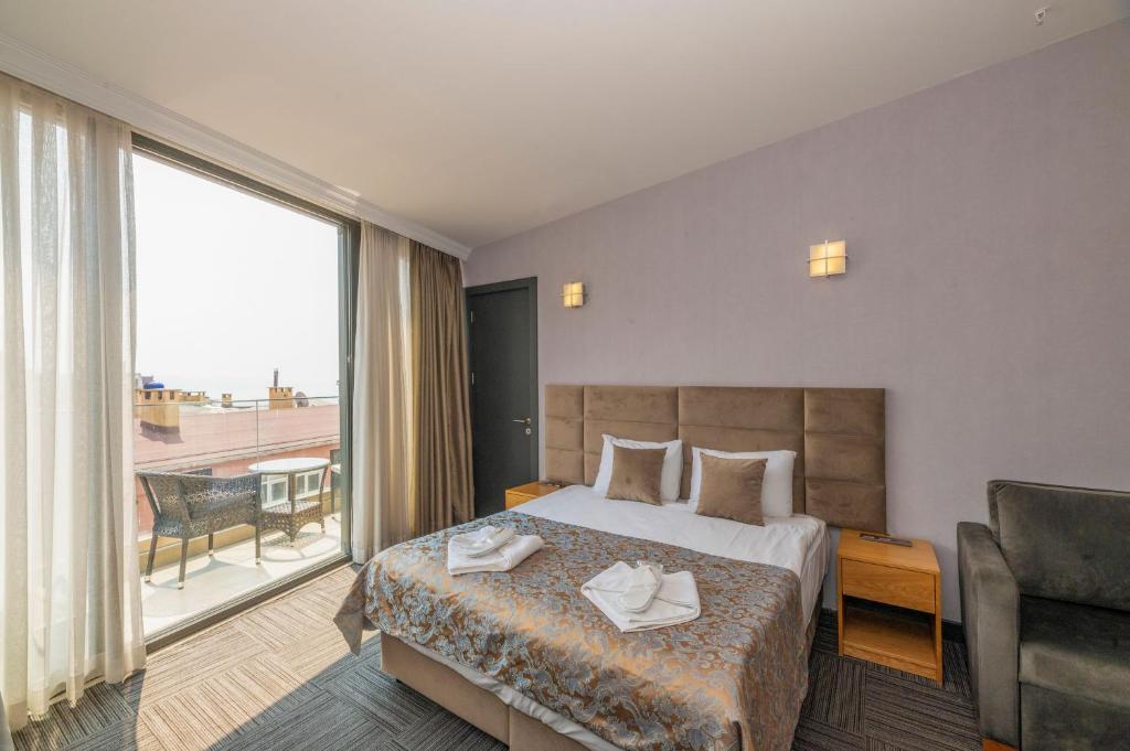 イスタンブールにあるTaksim Hotel V Plusのベッドと大きな窓が備わるホテルルームです。
