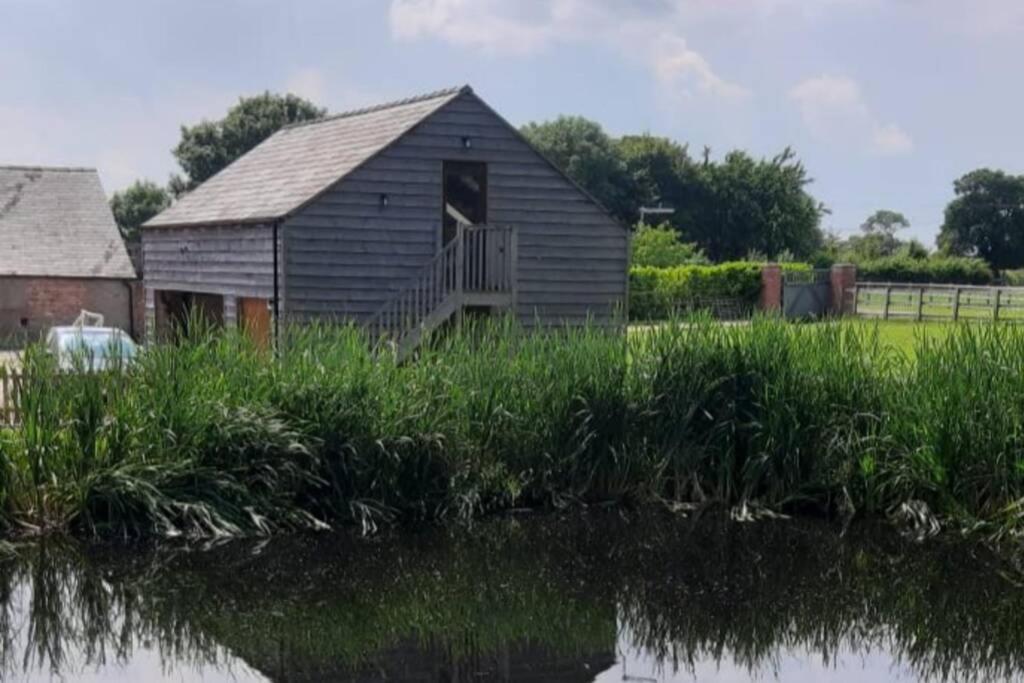 una vieja casa sentada junto a un cuerpo de agua en Swallows Retreat: A Country Loft Apartment en Hargrave