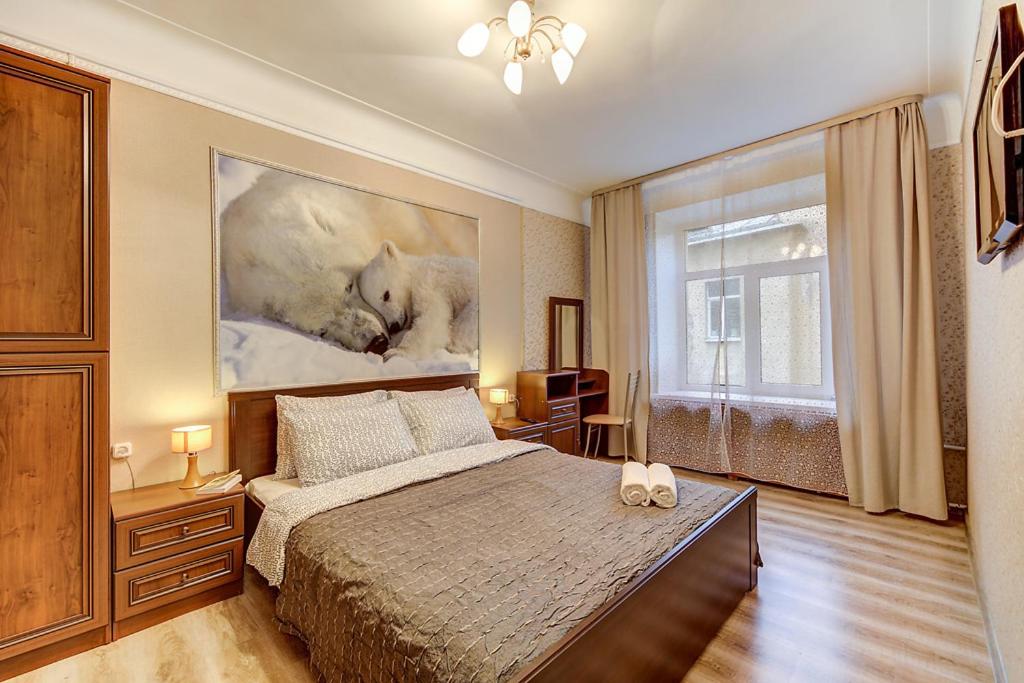 a bedroom with a bed and a painting of a wolf at Welcome Home Apartments Liteyniy 10 in Saint Petersburg